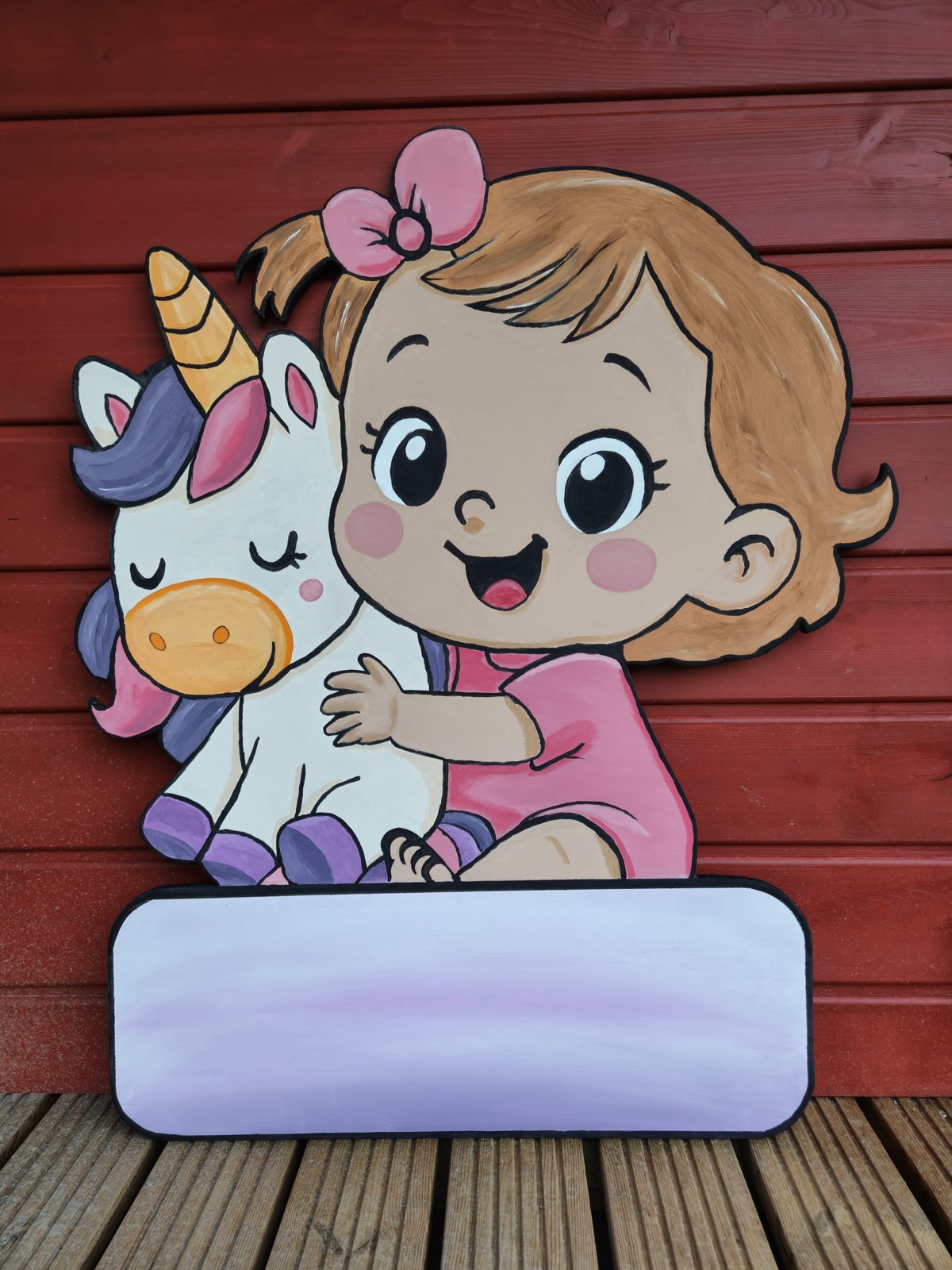 Baby-Mädchen mit Einhorn auf bemalter Holztafel mit freier Namensfläche