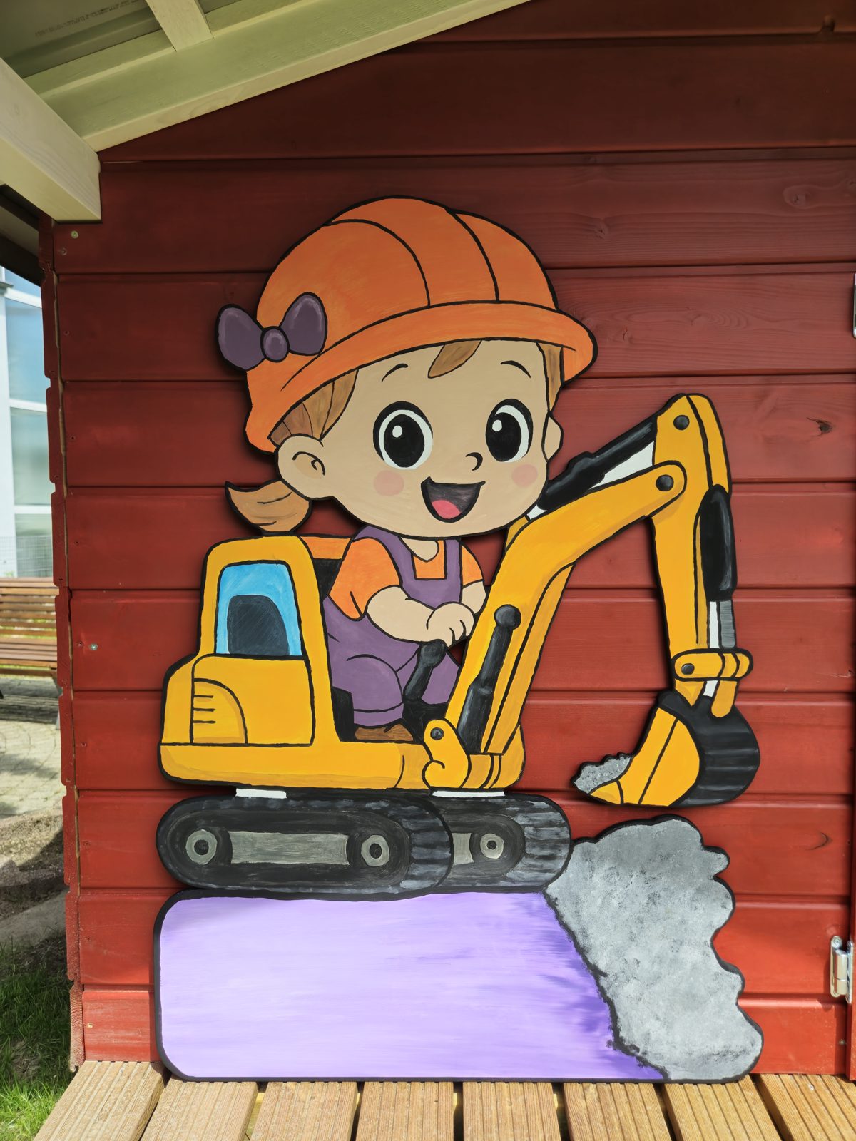 Kind mit Bauhelm auf einem Bagger, bemalte Holztafel