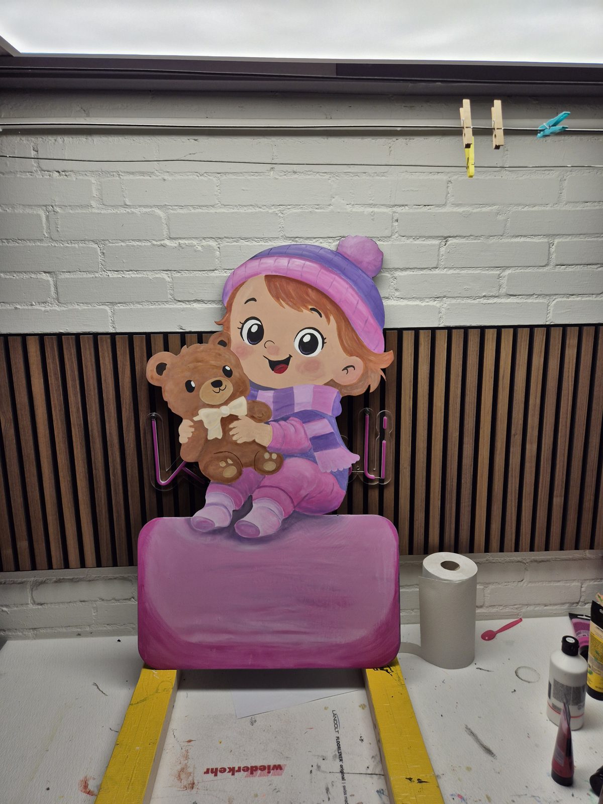 Mädchen mit Teddy, die Tafel noch in Arbeit auf dem Werktisch