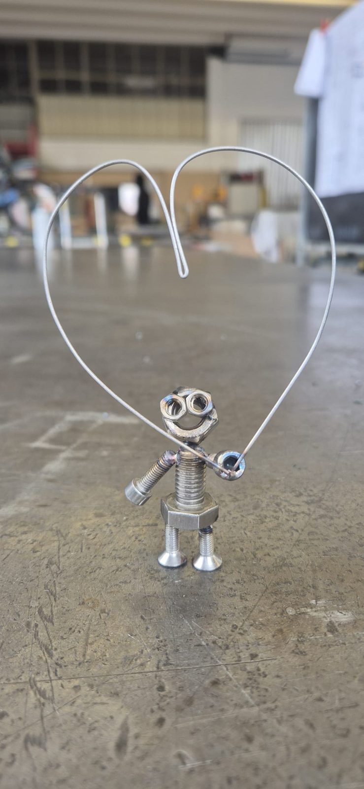 Kleines Metallmännchen unter einem Herz aus Draht