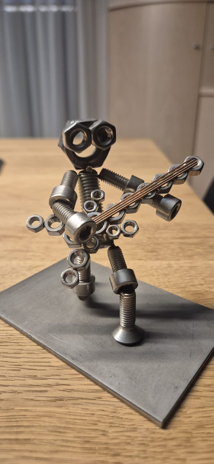 Metallmännchen mit Gitarre auf einem Holztisch