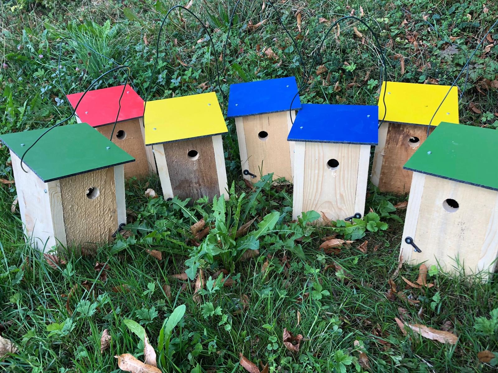Vogelhäuschen aus Holz mit grünen, gelben und blauen Dächern, Nahaufnahme