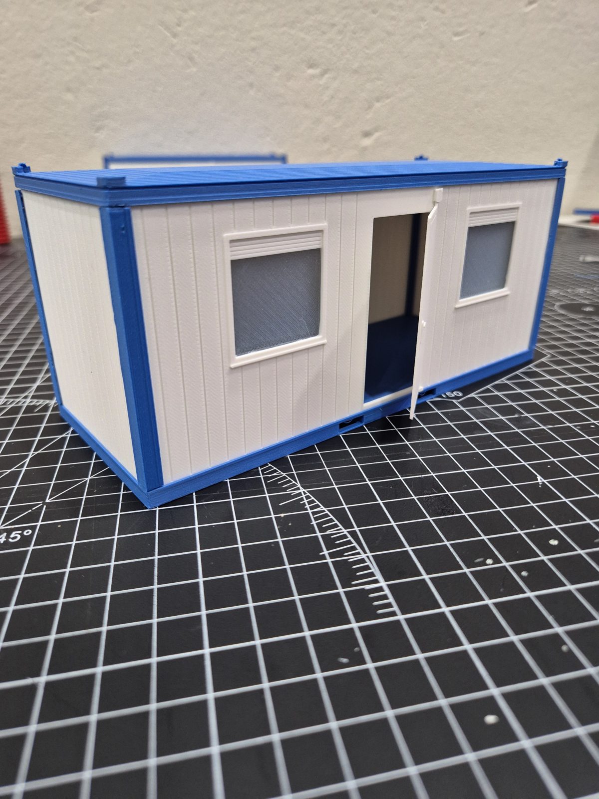 Modell eines Baucontainers in Weiss und Blau