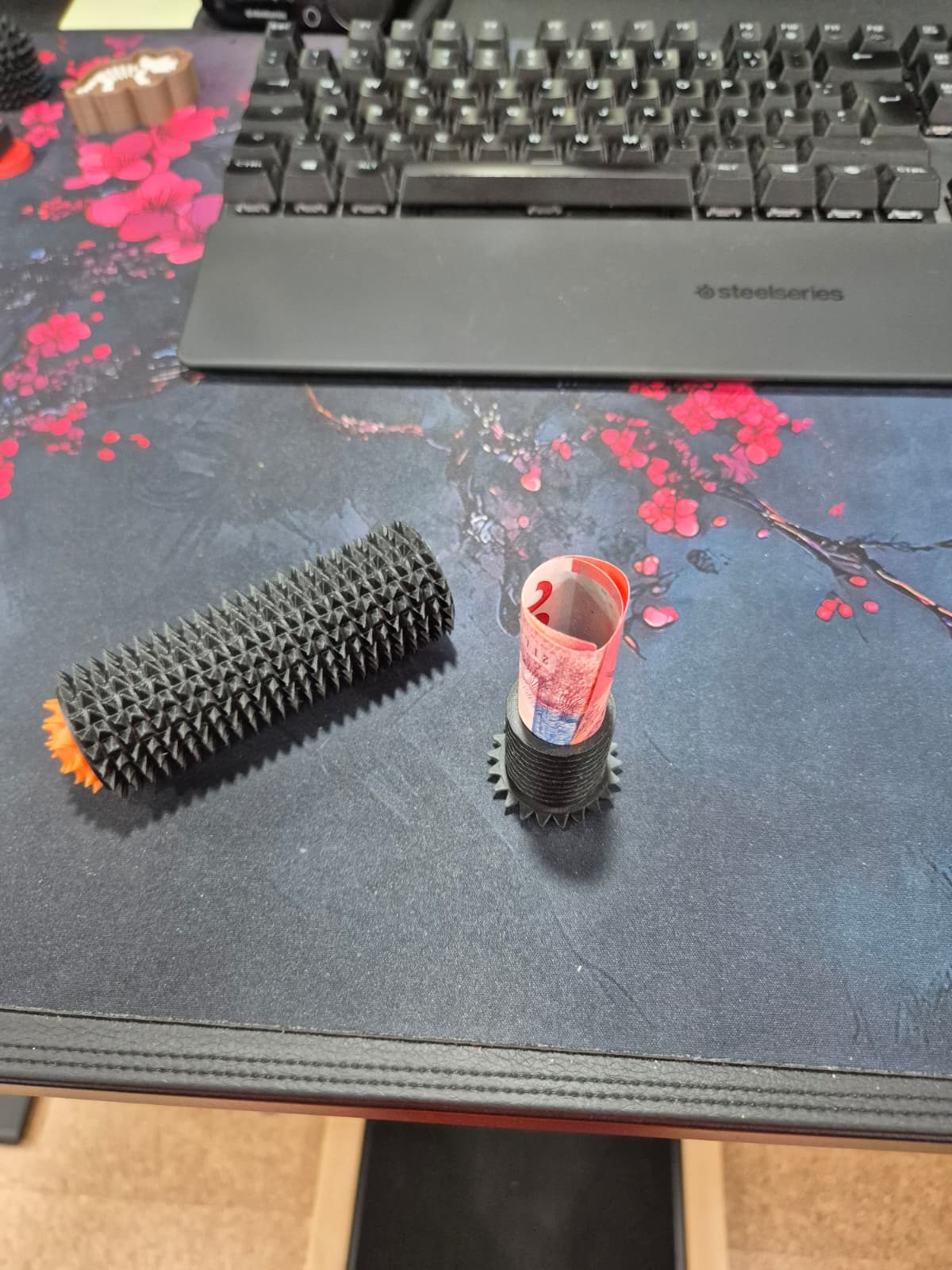 Zwei stachelige 3D-gedruckte Rollen auf einer Schreibtischunterlage