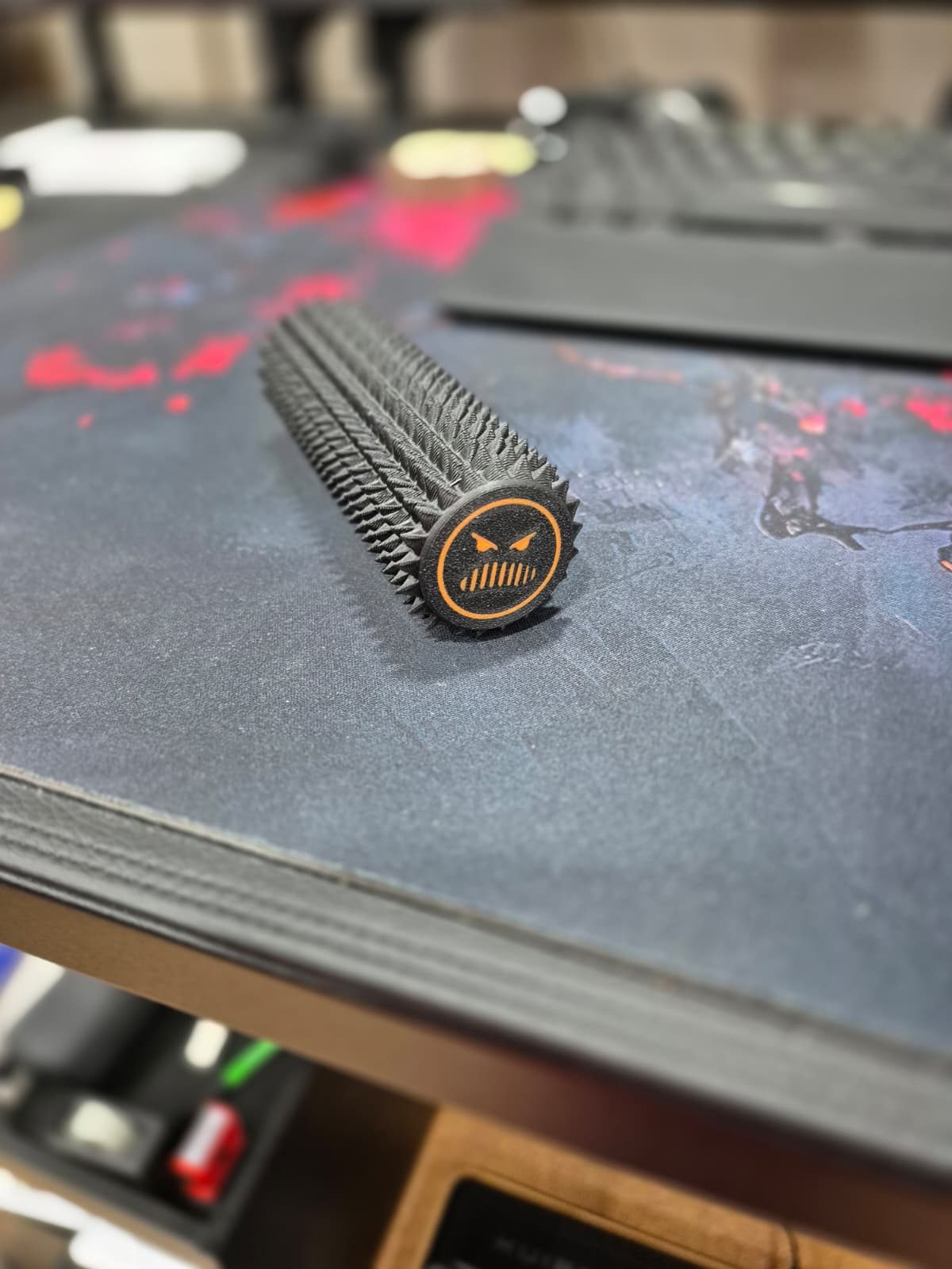 Stachelige schwarze 3D-gedruckte Rolle mit einem orangen Gesicht an der Stirnseite